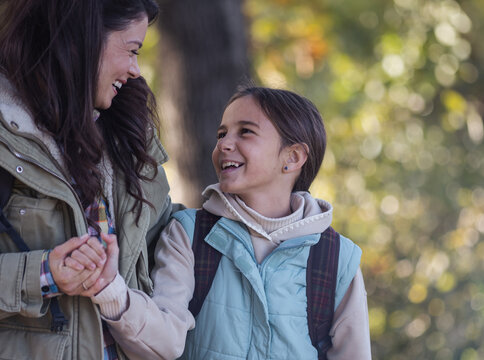 Mother and daughter smile during outdoor hiking activity