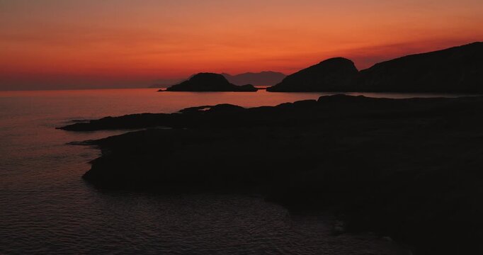 Beautiful orange and red sky in the early morning before sunrise on the Greek island Milos in Greece. 