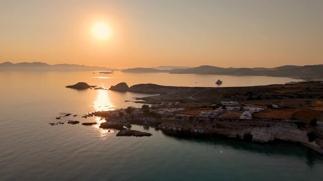 Sunrise over the village Mandrakia on the Greek island of Milos in Greece. The Aegean sea is calm on the coastline next to the small town. 