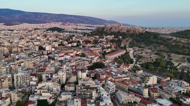 Low flying drone over the Greek city of Athens. Greece is a popular travel destination. An urban setting in a historical location with the Acropolis featured in the center. 