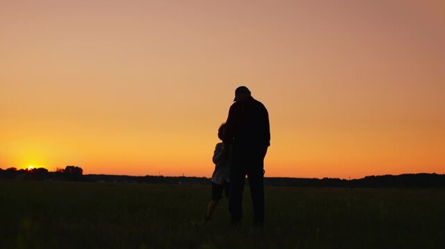 Silhouetted child running into open arms of elder at sunset on tranquil field, capturing emotional family reunion, love, and intergenerational bonding
