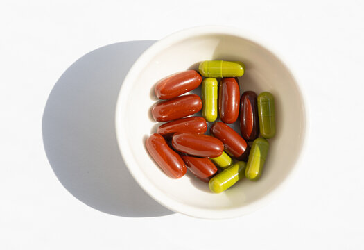 Brown gel pills, dark red capsules close up