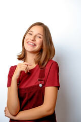 Fototapeta premium happy young schoolgirl with metallic dental braces smiling confidently portrait studio shot showing orthodontic hardware as part of a teenager lifestyle and self-acceptance concept isolated on white