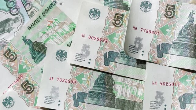 Money is scattered on the surface. Close-up of denominations of five Russian rubles