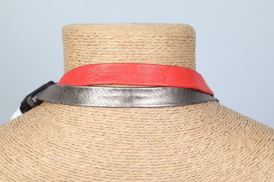 Bijou vintage en cuir rouge et argent sur un support en paille