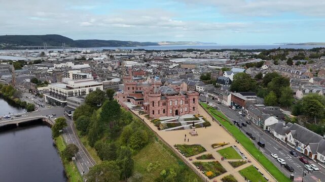 aerial drone video of Inverness Castle, River Ness bridge, city center, and Beauly Firth under overcast sky in Highland, Scotland