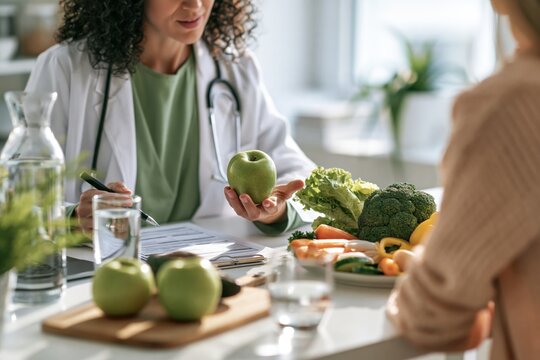 Nutritionist consulting patient about healthy diet and green apple