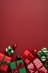 Naklejka premium Merry Christmas and Happy New Year concept with wrapped red and green gifts and ornaments on red vertical background
