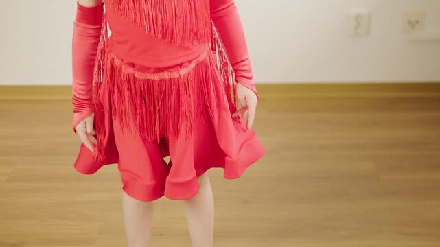 5-year-old blonde girl, little aspiring dancer in vibrant red dress performs Latin dance steps, showing energy, elegance, and early dedication to art