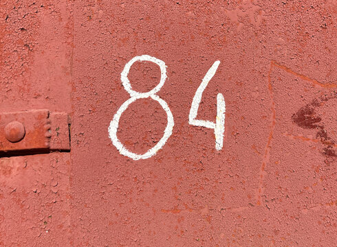 White number 84 on textured rusty background