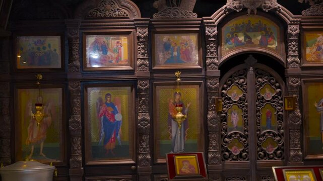 Ornate wooden iconostasis in an orthodox church. Majestic wooden iconostasis adorned with intricate carvings and traditional religious icons of saints and biblical scenes