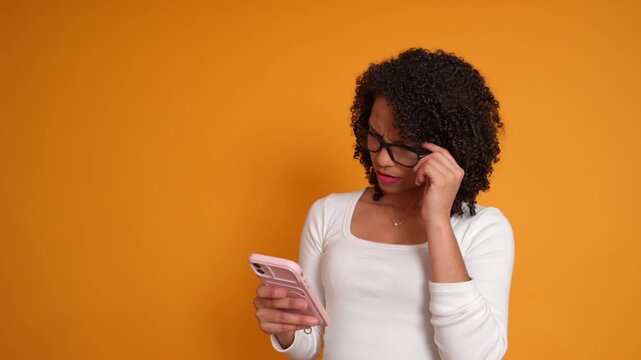 Black woman squinting at smartphone screen