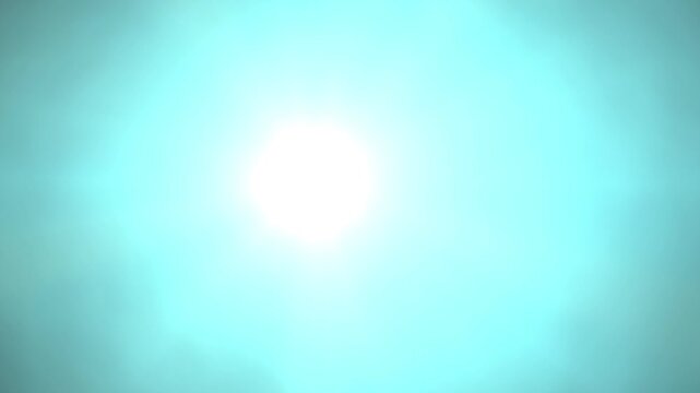 Soft blue haze swirls around bright sunbeams. Gentle glow spreads through dreamy, misty atmosphere