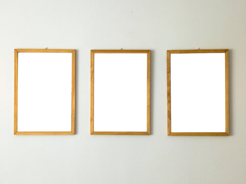 Three Empty Wooden Picture Frames Hanging Side by Side on White Wall Mockup