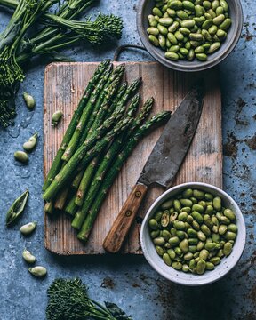 Rustic Food Photography of Fresh Asparagus Spears with Fava Beans and Broccolini on Wooden Board