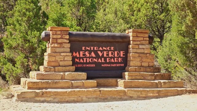 Rustic wooden entrance sign welcomes travelers along the highway into historic Mesa Verde National Park in southwestern Colorado