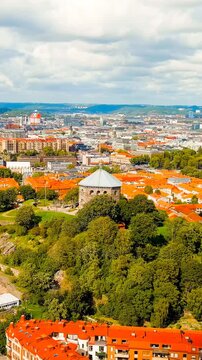 Vertical video. Gothenburg, Sweden. Skansen Kronan - A fortress on a hill with panoramic views of the city. Panorama of the city. Summer day. Cloudy weather. Drone footage. Rich colors
