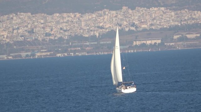 A sailing yacht is heading for the land with open sails. Zoom out.