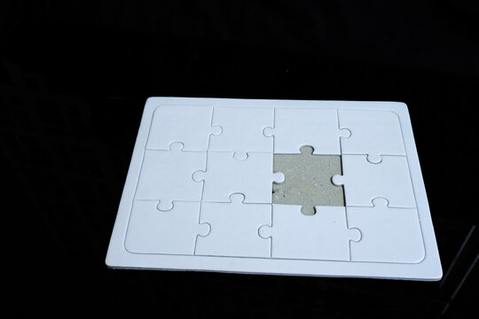 An incomplete puzzle with separate pieces. A puzzle arrangement against a dark background. Concept of finding solutions and problem-solving.
