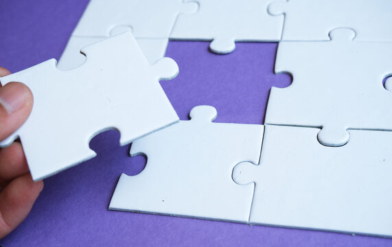 hand jigsaw puzzle pattern missing piece White jigsaw puzzle pattern top view to express alliance union team working solution success problem. Business assemble metaphor or puzzles game challenge.
