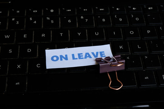 On Leave, annual leave for employees. An "ON LEAVE" sign with a paperclip resting on a keyboard. A break from work. Vacation, family event.
