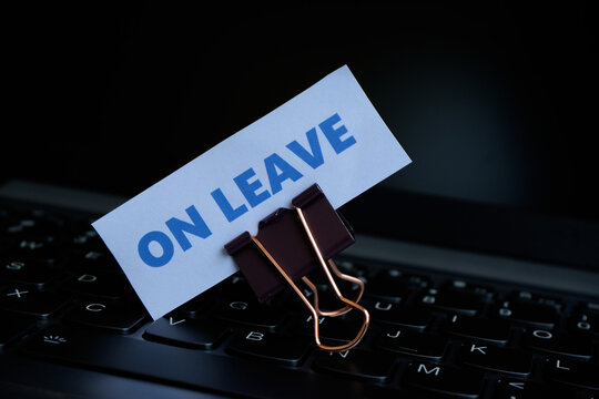 On Leave, annual leave for employees. An "ON LEAVE" sign with a paperclip resting on a keyboard. A break from work. Vacation, family event.