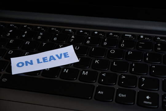 On leave, annual leave for an employee. An "ON LEAVE" sign sits above the keyboard, conveying the message at the workstation that the person is not currently working.