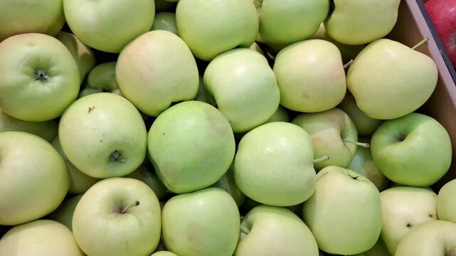 Fresh green apples stacked together on display at a grocery market. apple market, fresh fruits, organic farming, autumn harvest, seasonal produce, raw ingredients.