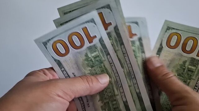 Hands holding US hundred dollar bills in close view. Cash payment, financial transaction, money handling, banking concept, business finance.