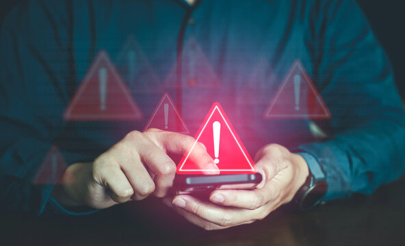Person holding smartphone with red shield security alert warning and exclamation mark icons
