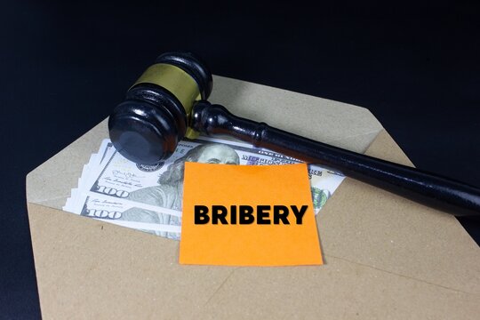 envelope filled with money beside a legal gavel and BRIBERY text, symbolizing corruption, illegal payments, bribery, justice, law enforcement, unethical business practices, nepotism