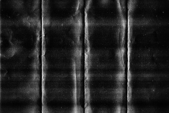 Grunge black folded paper texture with vertical crease lines and wrinkled effect