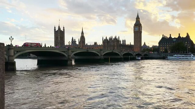 Wide angle view of Big Ben and Westminster Bridge over the River Thames at sunset in London, England.