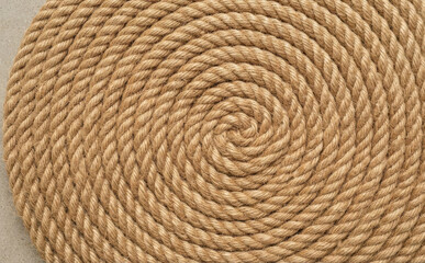 Fototapeta premium Coiled brown jute rope texture background in a spiral pattern showing natural fiber details for rustic design projects
