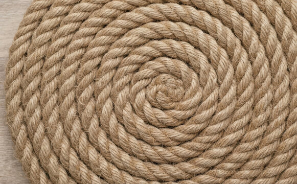 Coiled brown jute rope background texture close up, nautical maritime abstract pattern for rustic design and natural decor concepts