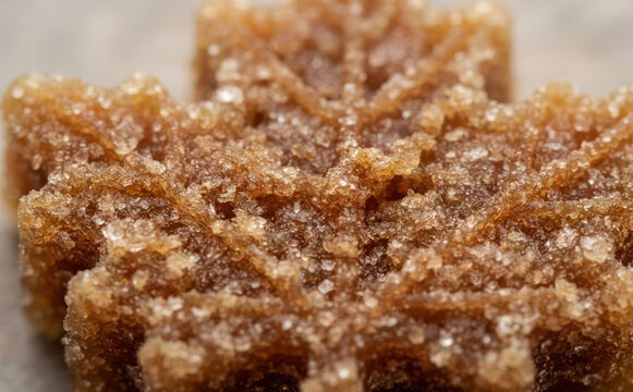 Macro close-up of a sweet maple sugar candy shaped like a leaf, representing traditional Canadian treats, delicious desserts, and gourmet food photography concepts.