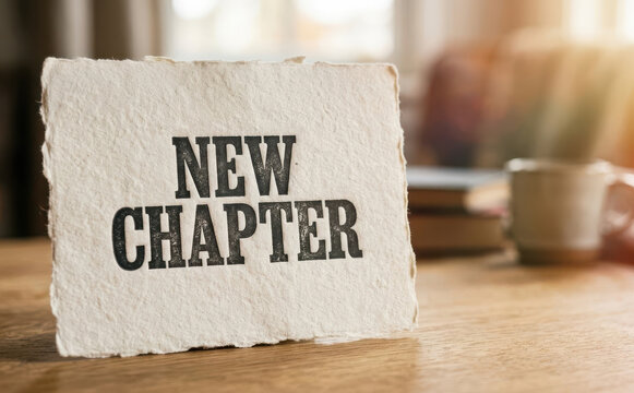 New chapter inspirational sign on a wooden table with coffee cup and books representing a fresh start, personal growth, and new beginnings in life