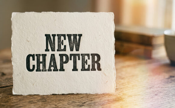 New chapter sign message on handmade paper on wooden table representing fresh start and new beginnings in life and business for motivation