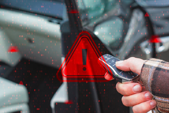 Hand holding car key fob remote with red warning sign overlay and binary code. Automotive cybersecurity threat, keyless entry hack, vehicle security vulnerability and car theft risk concept.