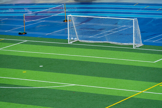 Soccer goal on green artificial turf football pitch with white boundary lines