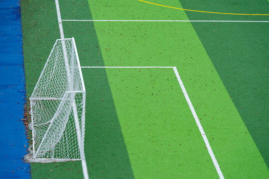 Soccer goal on green artificial turf football pitch with white boundary lines