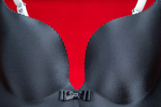 Black seamless bra with scalloped edge and small bow against bright red background