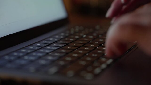Hands Typing on Laptop Keyboard in Warm Light Close Up