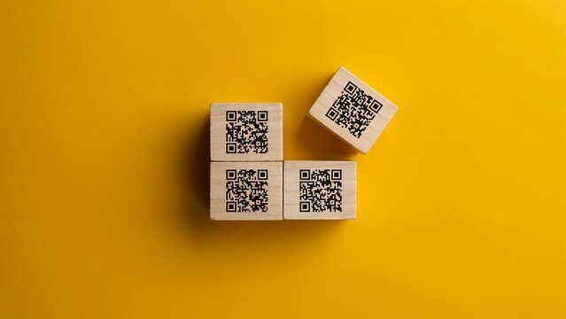 Four qr code cubes arranged on a yellow background representing digital technology and connectivity