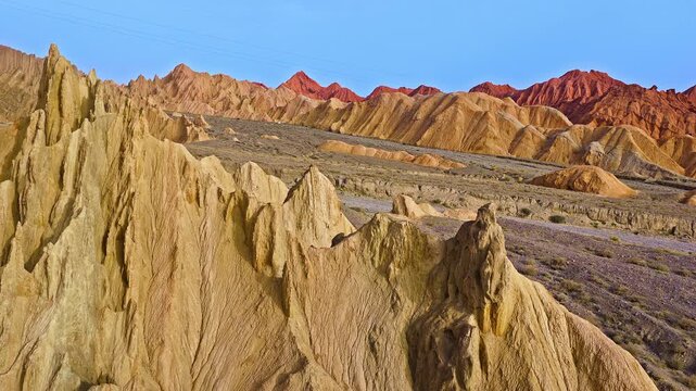 Aerial view of sandstone rock formations and arid mountain canyon landscape under a clear blue sky, Kuqa, Xinjiang, China
