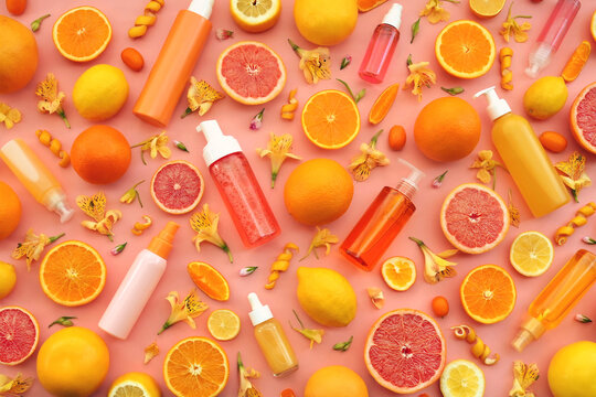 Cosmetic bottles on bright citrus fruits and flowers background, natural scincare cosmetics, beauty and facial care concept image, selective focus, shallow DOF