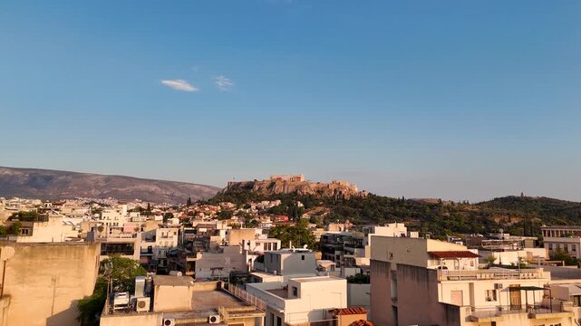 Low flying drone over the Greek city of Athens. Greece is a popular travel destination. An urban setting in a historical location with the Acropolis featured in the center. 