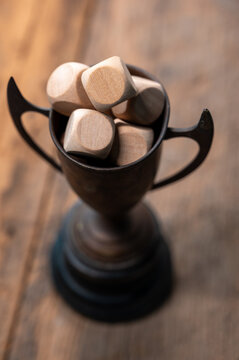 Wooden Trophies in a Vintage Cup on a Rustic Wooden Surface