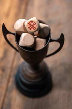 Wooden Trophy with Dice Featuring Target Symbols on a Rustic Table
