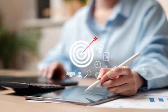 Business strategy goal planning and management success target. Woman hand using stylus pen on tablet with bullseye arrow mark.
